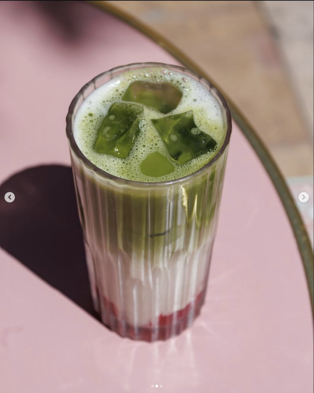 Iced matcha latte sur table rose